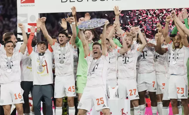 Bayern's Thomas Mueller, centre, celebrates with the championship shield after the German Bundesliga soccer match between FC Bayern Munich and Borussia Moenchengladbach in Munich, Germany, Saturday, May 10, 2025. (AP Photo/Matthias Schrader)