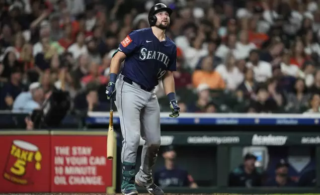 Seattle Mariners' Cal Raleigh watches his home run during the seventh inning of a baseball game against the Houston Astros in Houston, Friday, May 23, 2025. Julio Rodriguez also scored. (AP Photo/Ashley Landis)