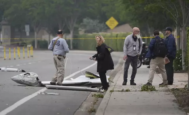 Investigators work at the site of a plane crash Friday, May 23, 2025, in San Diego. (AP Photo/Gregory Bull)