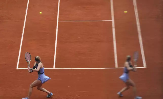Slovakia's Rebecca Sramkova is reflected in a glass as she plays Poland's Iga Swiatek during their first round match of the French Tennis Open, at the Roland-Garros stadium, in Paris, Monday, May 26, 2025. (AP Photo/Lindsey Wasson)