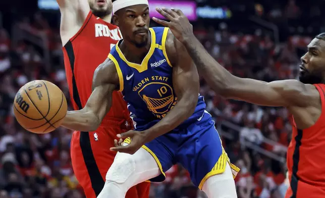 Jimmy Butler (10) passes to a teammate from under the basket in the first half as the Golden State Warriors played the Houston Rockets in Game 5 of the First Round of the NBA Playoffs at Toyota Center in Houston, Texas on Wednesday, April 30, 2025. (Carlos Avila Gonzalez/San Francisco Chronicle via AP)