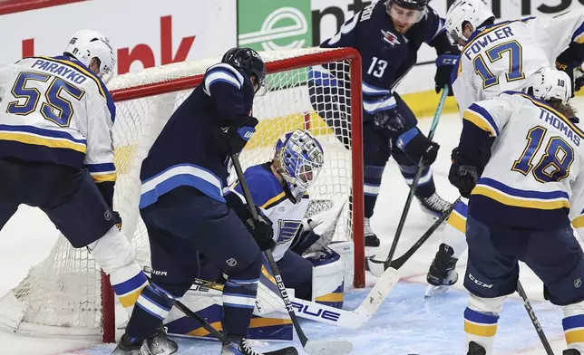 St. Louis Blues goaltender Jordan Binnington (50) makes the save off Winnipeg Jets' Gabriel Vilardi's (13) wraparound attempt during the third period of an NHL playoff game in Winnipeg on Wednesday, April 30, 2025. (John Woods/The Canadian Press via AP)