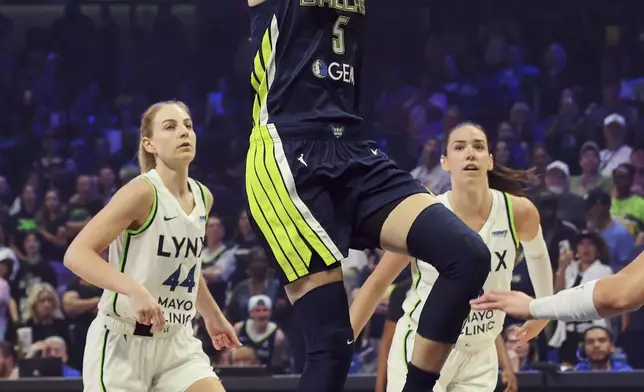 Dallas Wings guard Paige Bueckers (5) shoots after getting past Minnesota Lynx's Karlie Samuelson (44) in the first half of a WNBA basketball game Friday, May 16, 2025, in Arlington, Texas. (AP Photo/Richard Rodriguez)