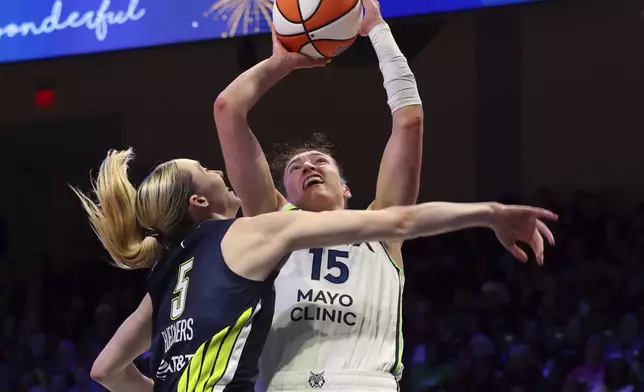 Dallas Wings guard Paige Bueckers (5) fouls Minnesota Lynx forward Jessica Shepard (15) who shoots in the second half of a WNBA basketball game Friday, May 16, 2025, in Arlington, Texas. (AP Photo/Richard W. Rodriguez)