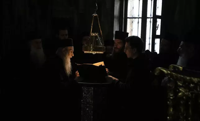 Monks pray during the afternoon liturgy at the Simonopetra, or Simonos Petra Monastery, home of the all-male autonomous community Agion Oros, or Holy Mountain, on the peninsula of Mount Athos in northern Greece, Monday, April 14, 2025. (AP Photo/Thanassis Stavrakis)