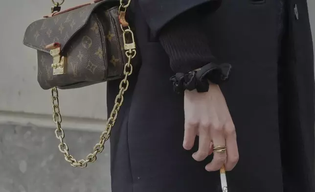 A woman holds a cigarette during a break in Paris, Wednesday, May 28 2025. (AP Photo/Michel Euler)