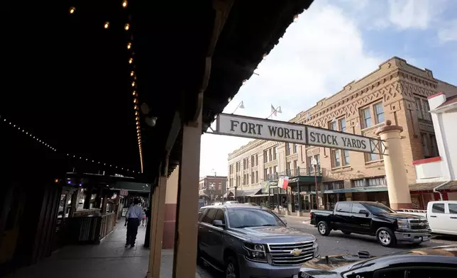 FILE - People walk down the sidewalk in the Fort Worth Stockyards, in Forth Worth, Texas, Monday, March 4, 2024. (AP Photo/Tony Gutierrez, File)