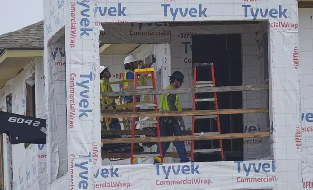 Construction workers build apartments in Princeton, Texas, Friday, May 16, 2025. (AP Photo/LM Otero)
