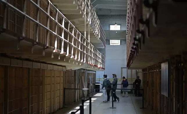 FILE - People tour the main cell house on Alcatraz Island in San Francisco, March 15, 2021, as the historic island prison was reopened to visitors after being closed since Dec. 2020, because of the coronavirus threat. (AP Photo/Eric Risberg, File)