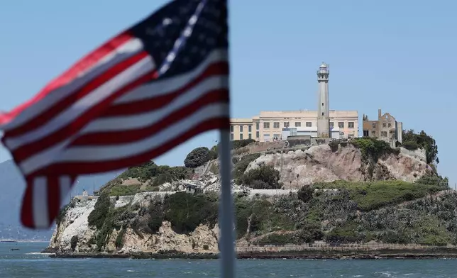 An American flag flies on the back of a ferry in front of Alcatraz Island in San Francisco, Monday, May 5, 2025. (AP Photo/Jed Jacobsohn)