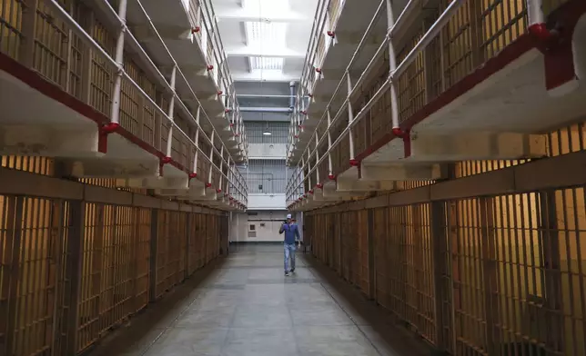 A visitor takes a tour of the prison cells on Alcatraz Island Monday, May 5, 2025, in San Francisco. (AP Photo/Jed Jacobsohn)
