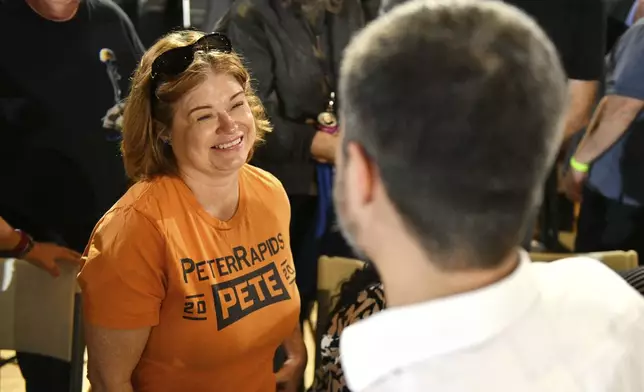 Brenda Masters of Cedar Rapids, Iowa, greets former U.S. Secretary of Transportation Pete Buttigieg, wearing a t-shirt she made while volunteering for Buttigieg during the 2020 Iowa Caucus, during a VoteVets Town Hall, Tuesday, May 13, 2025, in Cedar Rapids, Iowa. (AP Photo/Cliff Jette)