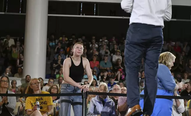 Ava Jones of Iowa City, a traumatic brain injury survivor and currently battling stage four Hodgkins lymphoma, asks former U.S. Secretary of Transportation Pete Buttigieg a question about the impacts of cuts to medical research and educational institutions during a VoteVets Town Hall, Tuesday, May 13, 2025, in Cedar Rapids, Iowa. (AP Photo/Cliff Jette)
