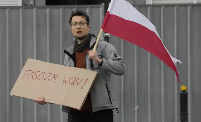 A man holds a poster that says "Fascism out" in Warsaw, Poland, Saturday, May 10, 2025. (AP Photo/Czarek Sokolowski)