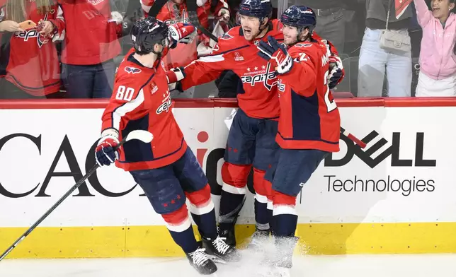 Washington Capitals right wing Brandon Duhaime (22) celebrates his empty net goal with left wing Pierre-Luc Dubois (80) and Connor McMichael, right, in the third period of Game 5 of a first-round NHL hockey playoff series against the Montreal Canadiens Wednesday, April 30, 2025, in Washington. (AP Photo/Nick Wass)