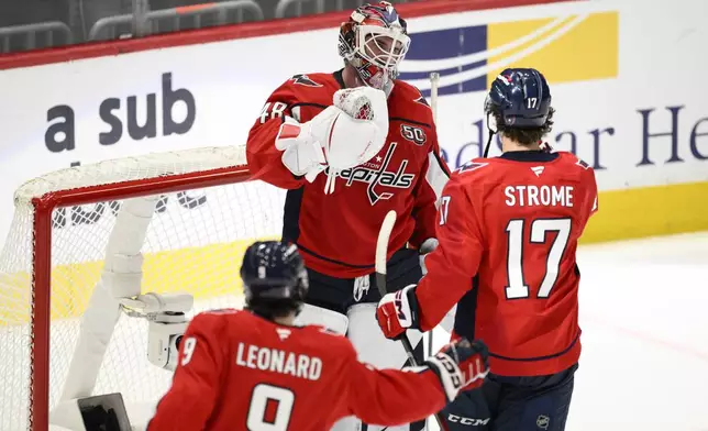 Washington Capitals goaltender Logan Thompson (48) celebrates with center Dylan Strome (17) and Ryan Leonard at the end of Game 5 of a first-round NHL hockey playoff series against the Montreal Canadiens Wednesday, April 30, 2025, in Washington. (AP Photo/Nick Wass)