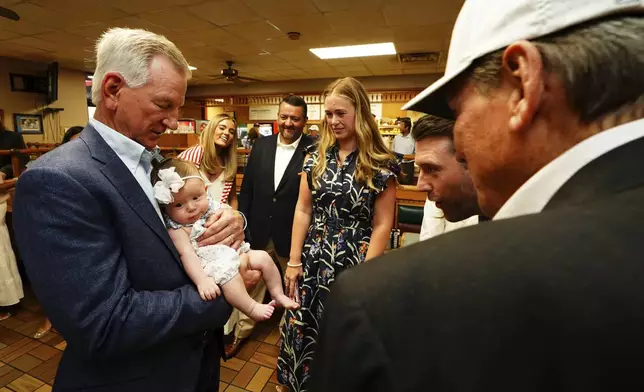 U.S. Sen. Tommy Tuberville, R-Ala., holds his granddaughter Rosie Grace Tuberville after he announced his plans to run for the governor of Alabama in 2026, Tuesday May 27, 2025 at Byron's Smokehouse in Auburn, Ala. (AP Photo/ John David Mercer)