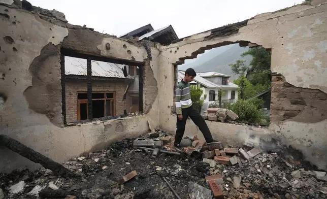 A Kashmiri village boy walks inside a house damaged by Pakistani artillery shelling, at Salamabad village in Uri ,north of Srinagar, Indian controlled Kashmir, Thursday, May 8, 2025. (AP Photo/Mukhtar Khan)