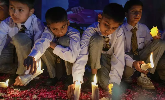Students place candles during a candle light vigil for children killed in the Indian missile strikes, in Islamabad, Pakistan Thursday, May 8, 2025. (AP Photo/Anjum Naveed)