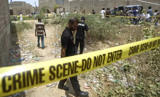Pakistani investigators examine at a cordoned off site, where Pakistan's air defense system shot down a suspected Indian drone, in Karachi, Pakistan, Thursday, May 8, 2025. (AP Photo/Fareed Khan)