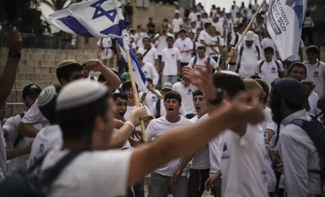 Israelis wave national flags during a march marking Jerusalem Day, an Israeli holiday celebrating the capture of east Jerusalem in the 1967 Mideast war, in Jerusalem's Old City, Monday, May 26, 2025. (AP Photo/Leo Correa)