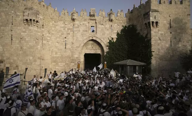 Israelis wave national flags during a march marking Jerusalem Day, an Israeli holiday celebrating the capture of east Jerusalem in the 1967 Mideast war, in Jerusalem's Old City, Monday, May 26, 2025. (AP Photo/Leo Correa)