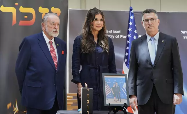 U.S. Homeland Security Secretary Kristi Noem poses for a photo with Israel's Foreign Minister Gideon Sa'ar and U.S. Ambassador to Israel Mike Huckabee during a memorial event honoring Yaron Lishinsky and Sarah Milgrom in Jerusalem, Monday, May 26, 2025. (AP Photo/Alex Brandon, Pool)