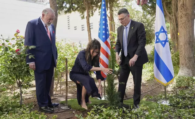 U.S. Homeland Security Secretary Kristi Noem, center, and Israel's Foreign Minister Gideon Sa'ar, right, plant a tree as U.S. Ambassador to Israel Mike Huckabee looks on, in Jerusalem, Monday, May 26, 2025. (AP Photo/Alex Brandon, Pool)