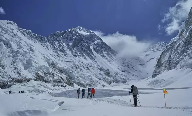 Mountaineers ascend from Camp 2 to Camp 3 on the way to the summit of Mount Everest which is visible in the background, in Nepal, May 2, 2025. (AP Photo/Pasang Rinzee Sherpa)