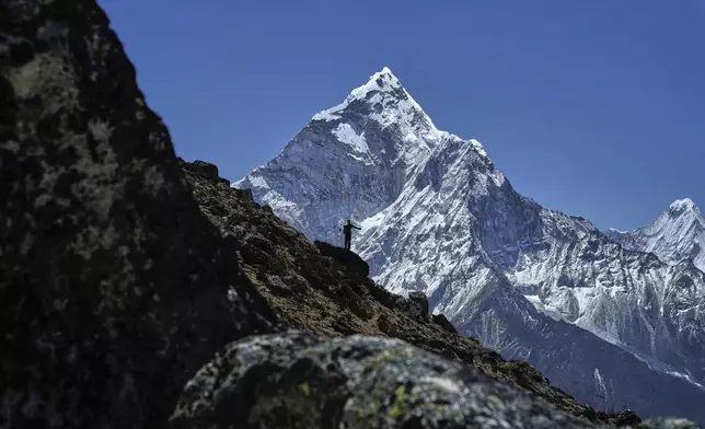A mountaineer is silhouetted against Mount Ama Dablam on his way to the summit of Mount Everest in Nepal, April 24, 2025. (AP Photo/Pasang Rinzee Sherpa)