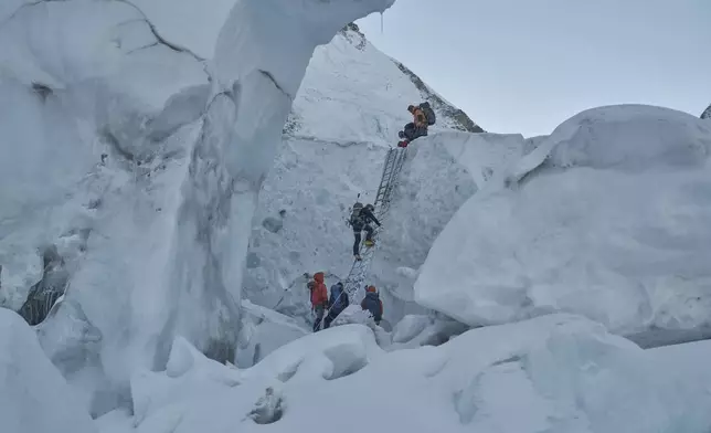 Mountaineers negotiate Khumbu Icefall as they ascend toward the summit of Mount Everest, Nepal, May 11, 2025. (AP Photo/Pasang Rinzee Sherpa)