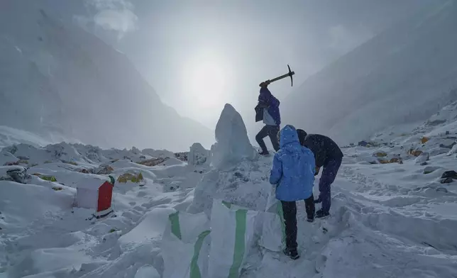 A member of the kitchen crew of an expedition to the summit of Mount Everest collects ice for drinking water at Camp 1, Nepal, May 2, 2025. (AP Photo/Pasang Rinzee Sherpa)