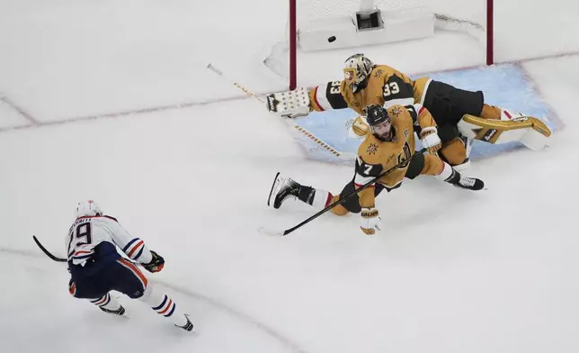 Edmonton Oilers center Leon Draisaitl (29) scores against Vegas Golden Knights goaltender Adin Hill (33) during overtime of Game 2 of a second-round NHL hockey playoff series Thursday, May 8, 2025, in Las Vegas. (AP Photo/John Locher)