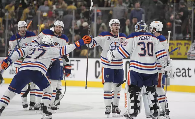 Edmonton Oilers celebrate after defeating the Vegas Golden Knights in overtime of Game 2 of a second-round NHL hockey playoff series Thursday, May 8, 2025, in Las Vegas. (AP Photo/John Locher)