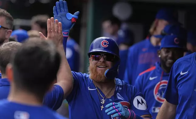 Chicago Cubs' Justin Turner celebrates in the dugout after hitting a home run in the third inning of a baseball game against the Cincinnati Reds, Saturday, May 24, 2025, in Cincinnati. (AP Photo/Carolyn Kaster)