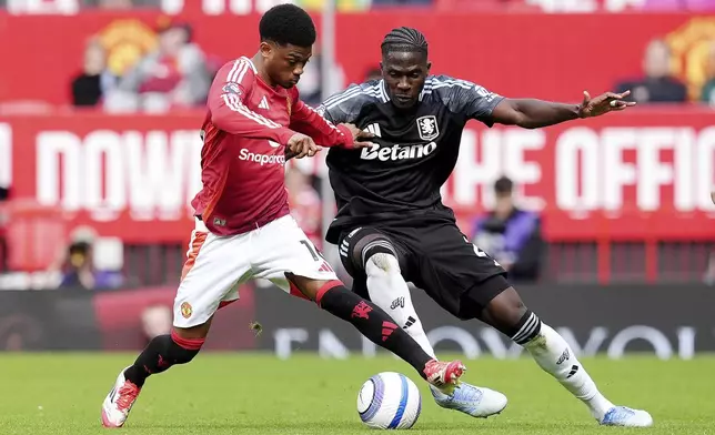 Manchester United's Amad Diallo, left, and Aston Villa's Amadou Onana battle for the ball during the English Premier League soccer match between Manchester United and Aston Villa at Old Trafford, Manchester, England, Sunday May 25, 2025. (Martin Rickett/PA via AP)