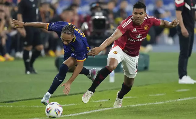 Manchester United's Casemiro, right, fights for the ball with ASEAN All-Star Australia's Kealey Adamson during the Challenge Cup Malaysia 2025 soccer match in Kuala Lumpur, Malaysia, Wednesday, May 28, 2025. (AP Photo/Vincent Thian)