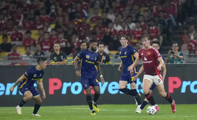 Manchester United's Rasmus Hojlund, right, fights for the ball with ASEAN All-Star Cambodia's Mo Kan, center, during the Challenge Cup Malaysia 2025 soccer tournament in Kuala Lumpur, Malaysia, Wednesday, May 28, 2025. (AP Photo/Vincent Thian)
