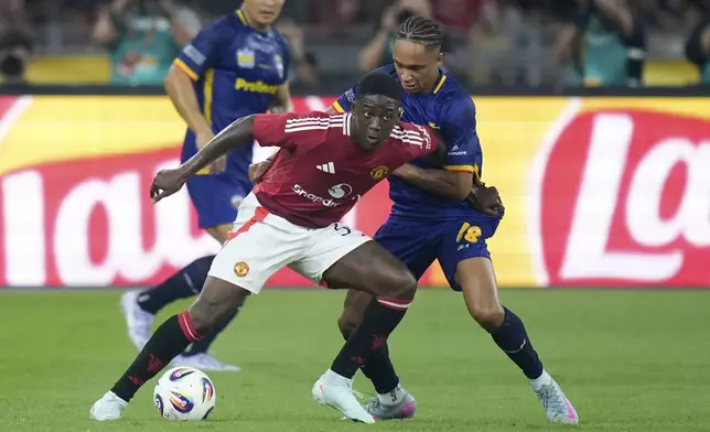 Manchester United's Kobbie Mainoo, left, fights for the ball with AASEAN All-Star Australia's Kealey Adamson during the Challenge Cup Malaysia 2025 soccer tournament in Kuala Lumpur, Malaysia, Wednesday, May 28, 2025. (AP Photo/Vincent Thian)
