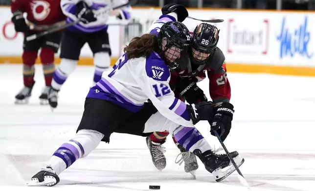 Ottawa Charge's Emily Clark (26) gets tangled up with Minnesota Frost's Kelly Pannek (12), during third period of a PWHL playoff hockey game in the Walter Cup Final, in Ottawa, on Tuesday, May 20, 2025. (Justin Tang/The Canadian Press via AP)