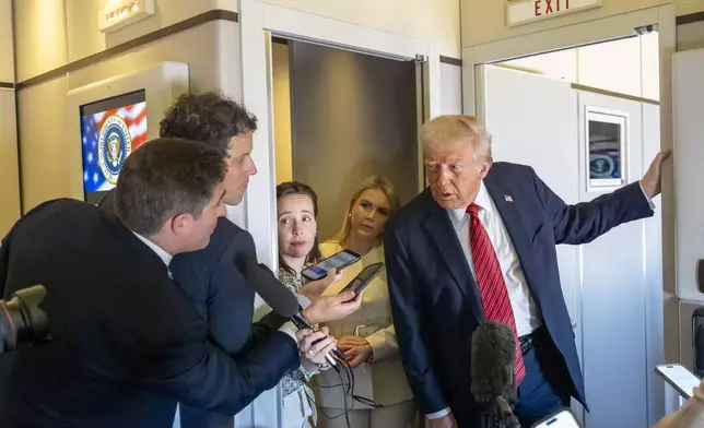 President Donald Trump speaks to reporters aboard Air Force One en route from Riyadh, Saudi Arabia to Doha, Qatar, Wednesday, May 14, 2025. (AP Photo/Alex Brandon)