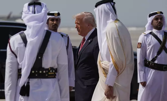 President Donald Trump is greeted by Qatar's Emir Sheikh Tamim bin Hamad Al Thani as he arrives on Air Force One at Hamad International Airport in Doha, Qatar, Wednesday, May 14, 2025. (AP Photo/Alex Brandon)