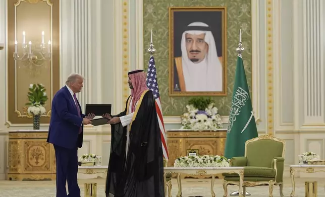 President Donald Trump and Saudi Crown Prince Mohammed bin Salman exchange documents during a signing ceremony at the Royal Palace, Tuesday, May 13, 2025. (AP Photo/Alex Brandon)