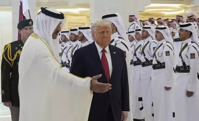 Qatar's Emir Sheikh Tamim bin Hamad Al Thani welcomes President Donald Trump during an official welcoming ceremony at the Amiri Diwan in Doha, Qatar, Wednesday, May 14, 2025. (AP Photo/Alex Brandon)
