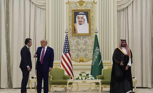 President Donald Trump speaks with Secretary of Defense Pete Hegseth as they attend a signing ceremony with Saudi Crown Prince Mohammed bin Salman at the Royal Palace in Riyadh, Saudi Arabia, Tuesday, May 13, 2025. (AP Photo/Alex Brandon)