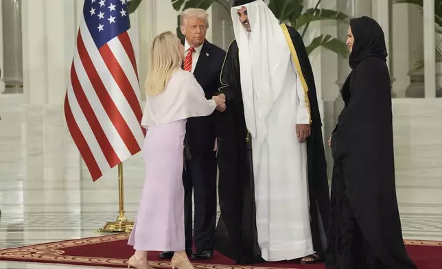 President Donald Trump looks toward Qatar's Emir Sheikh Tamim bin Hamad Al Thani as the emir shakes hands with White House Press Secretary Karoline Leavitt before a state dinner at Lusail Palace in Doha, Qatar, Wednesday, May 14, 2025. (AP Photo/Alex Brandon)