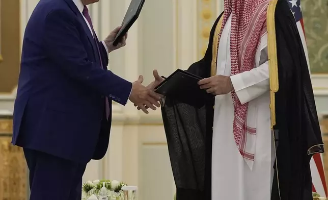 President Donald Trump and Saudi Crown Prince Mohammed bin Salman shake hands after exchanging documents during a signing ceremony at the Royal Palace in Riyadh, Saudi Arabia, Tuesday, May 13, 2025. (AP Photo/Alex Brandon)