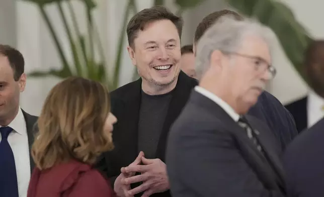 Elon Musk gestures as he arrives for a state dinner hosted by Qatar's Emir Sheikh Tamim bin Hamad Al Thani in honor of President Donald Trump at Lusail Palace in Doha, Qatar, Wednesday, May 14, 2025. (AP Photo/Alex Brandon)