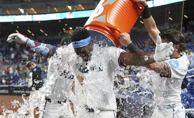 Miami Marlins' Jesus Sanchez is doused with ice after hitting a walk-off triple to defeat the Chicago Cubs in a baseball game Monday, May 19, 2025, in Miami. (AP Photo/Lynne Sladky)