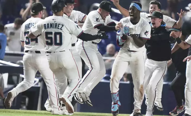 Miami Marlins' Jesus Sanchez, second from right, celebrates after hitting a walk-off triple in the ninth inning to defeat the Chicago Cubs in a baseball game Monday, May 19, 2025, in Miami. (AP Photo/Lynne Sladky)